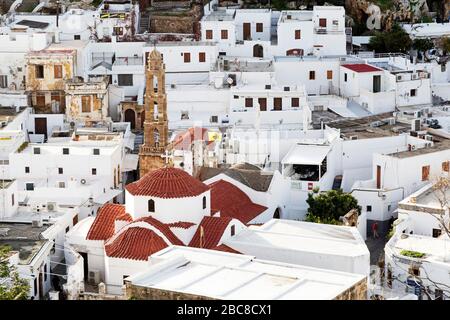 White houses in Lindos on Rhodes, Greece. The Church of Panagia rises above buildings in the town. Stock Photo