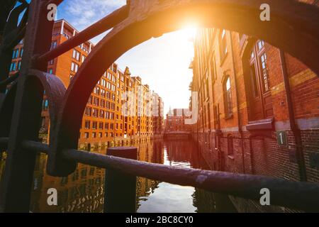 Speicherstadt Hamburg. Famous landmark of old buildings made with red bricks. Bridge and sun rays in low angle view. Stock Photo