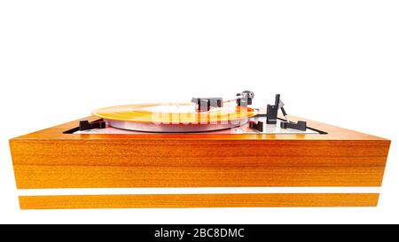 Vintage turntable with a red vinyl isolated on white. Wooden plinth. Retro audio equipment. Stock Photo