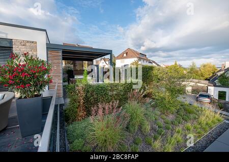 Bed in front of a modern house with grasses and rock garden Stock Photo