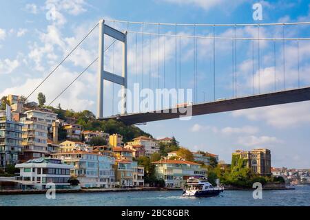 Istanbul, Turkey.  Boat passing beneath the Bosphorus Bridge which connects Europe with Asia. Stock Photo