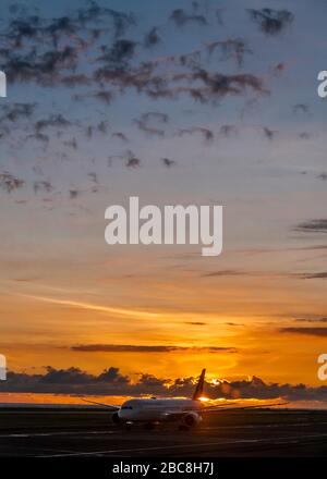 Vertical view of an aeroplane on the runway at sunset. Stock Photo