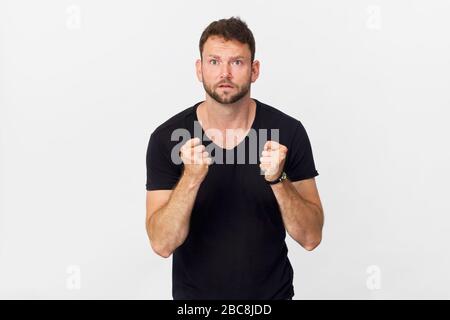 Happy young man with crossed fingers and smiling portrait against white background Stock Photo
