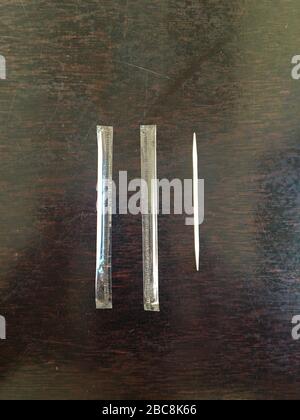 Disposable wooden toothpick in plastic bag on dark wooden table. Toothpicks in plastic wrap on the wood table. Concept of overuse of material - People Stock Photo