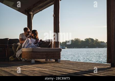 Smiling couple looking at each other by the riverr. Beautiful autumn day Stock Photo