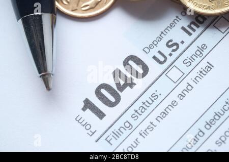 US tax form with pen and coins on table, close up Stock Photo