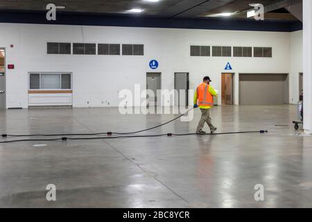 Detroit, Michigan, USA. 2nd Apr, 2020. An electrician runs wiring for what will be an emergency field hospital at the TCF convention center. The 1,000-bed hospital will care for Covid-19 patients. Credit: Jim West/Alamy Live News Stock Photo