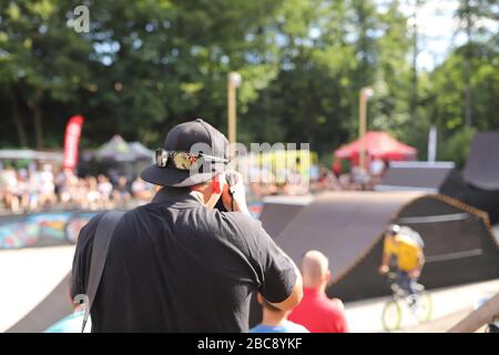 Young boy jumping with his BMX Bike. BMX Rider in action at bike sport. Cool athlete cyclist on a bike. Pump biking. photographer taking photo of adre Stock Photo