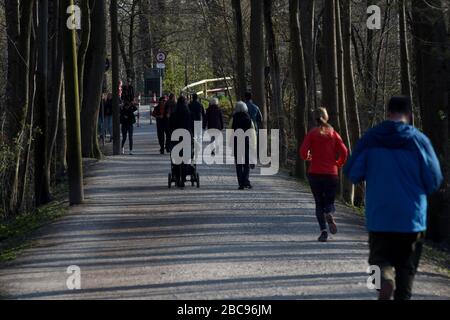 Munich, Germany. 03rd Apr, 2020. Walkers and joggers move along the banks of the Isar near the zoo Hellabrunn in bright sunshine in the fresh air. Credit: Felix Hörhager/dpa/Alamy Live News Stock Photo