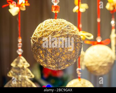 Christmas decoration in the form of ball of woven threads in ocher colors Stock Photo