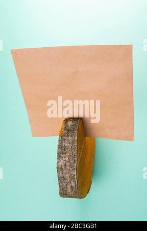 Wooden round board and craft paper on mint background Stock Photo