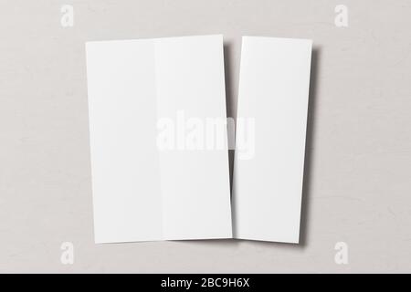 Blank vertical A4 leaflet on white wooden background. Bi-fold or half-fold opened and folded brochure isolated with clipping path. View directly above Stock Photo