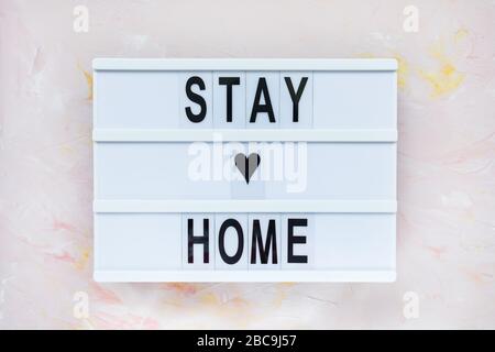 STAY HOME text on vintage lightbox on pink pastel background. Covid-19 quarantine concept. Copy space. Stock Photo