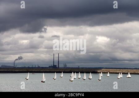 Sailing boats at Dun Laoghaire harbour with Poolbeg Stacks in the distance Stock Photo