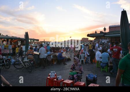 Crowds of locals and tourists mill at sunset in Djemma El Fna, Marrakech's main square. Stock Photo