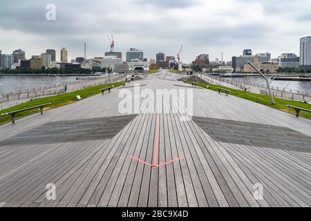 The scenic architecture design of Yokohama Passenger Terminal (Osanbashi Pier) with the city skyline in the background, Japan Stock Photo
