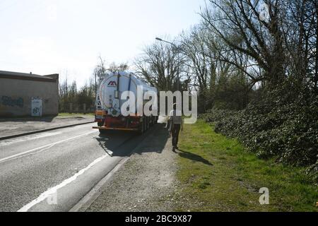Strasbourg, France - Mar 18, 2020: Rear view of beautiful single woman walking on the trottoir with Mauffrey truck on the street Stock Photo