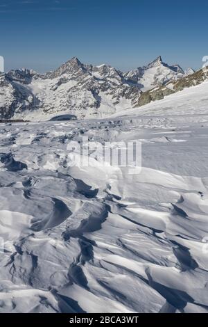 Switzerland, Valais, Zermatt, snowdrifts on the glacier of the Breithorn plateau with Obergabelhorn and Zinalrothorn Stock Photo