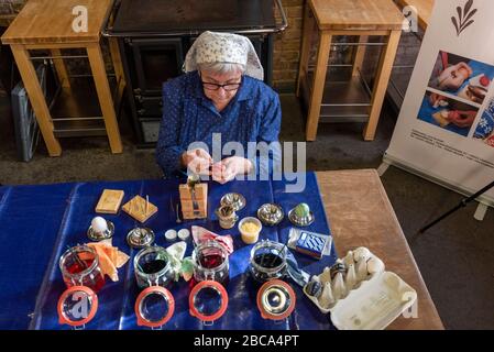 A woman in Sorbian dress decorates Easter eggs. Stock Photo