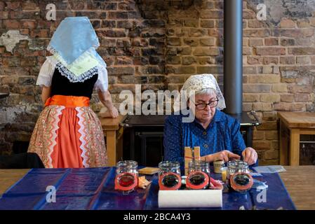 Woman in Sorbian traditional costume, woman in Sorbian traditional costume (from left to right) dye Easter eggs. Stock Photo