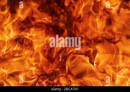 Blazing abstract natural red fire flames texture or background. Beautiful dangerous motion blurred fumes, atmospheric dispersion, high temperature Stock Photo