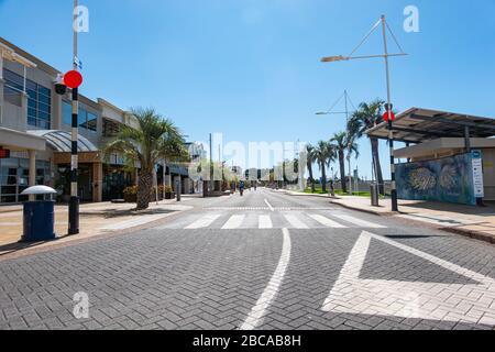 Tauranga New Zealand - April 4 2020: Tauranga downtown empty streets and buildings during covid-19 state of emergency with four cyclists in distance. Stock Photo