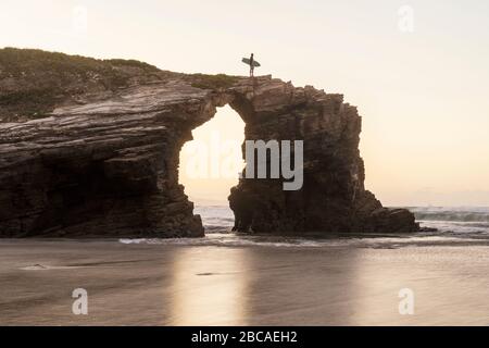 Spain, north coast, Galicia, national park, cathedral beach, Playa de las Catedrales, surfer with board on rocks Stock Photo