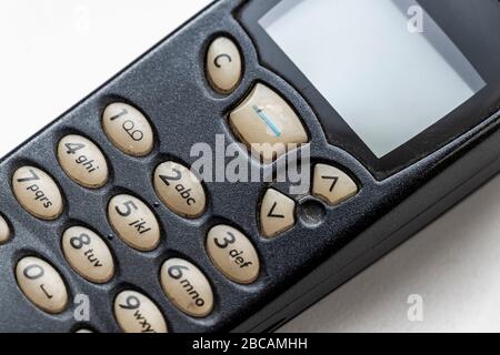 Old cellular push-button telephone close-up on a white windowsill. Stock Photo