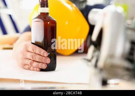 Arm of drunken worker in yellow helmet Stock Photo