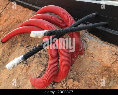 coiled corrugated pipes and high voltage cables. Stock Photo