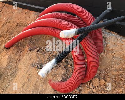 coiled corrugated pipes and high voltage cables. Stock Photo