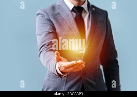 Man holds his hand in front of him showing off an object in the palm of his hand Stock Photo
