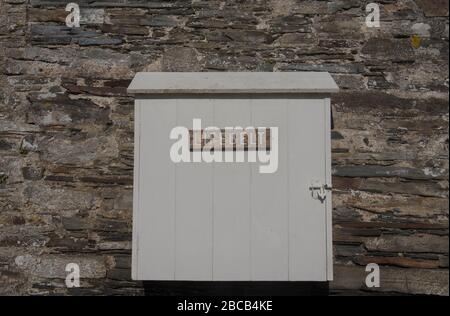 Old Wooden Box Attached to a Granite Stone Wall Containing a Life Belt and Sign on the Outside at Cotehele Quay on the River Tamar in Rural Cornwall, Stock Photo