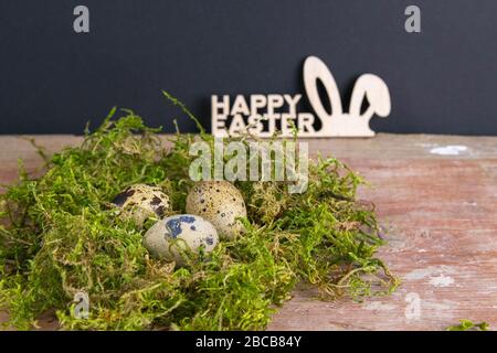 Quail eggs stand in a nest of green moss next is a sign of the sorly Easter. Top views Stock Photo