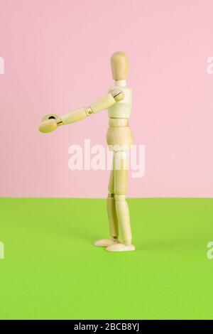 The figure of a wooden man stretches his arms forward, he wants to hug someone. The concept of loneliness, the need for attention. Stock Photo