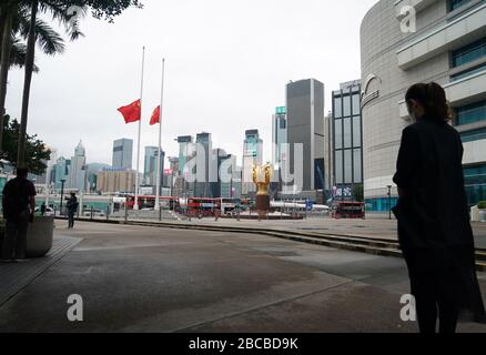 Hong Kong, China. 4th Apr, 2020. Chinese national flag and the flag of the Hong Kong Special Administrative Region (SAR) fly at half-mast to mourn for martyrs who died in the fight against the novel coronavirus disease (COVID-19) outbreak and compatriots who died of the disease in Hong Kong, south China, April 4, 2020. Credit: Li Gang/Xinhua/Alamy Live News Stock Photo