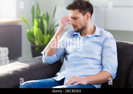 Man On Sofa Having Headache Stock Photo