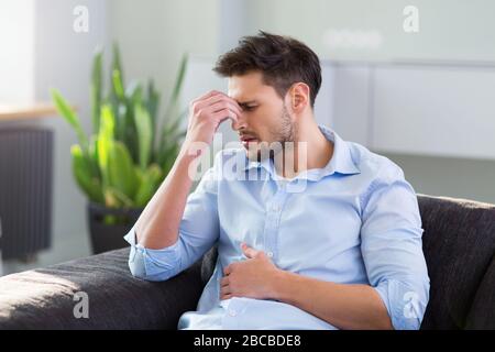 Man On Sofa Having Headache Stock Photo
