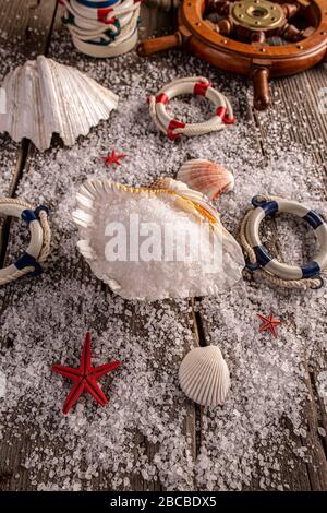 Pile of sea salt in shell on wooden background Stock Photo
