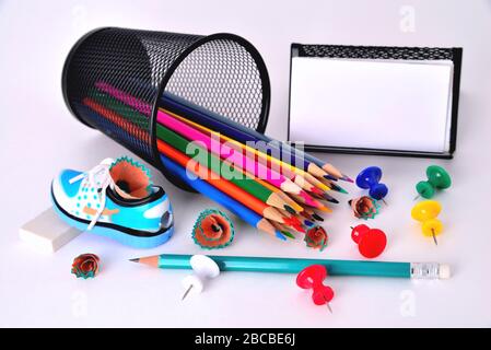 Color pencils, pencil sharpener, business card holder, eraser on white background Stock Photo