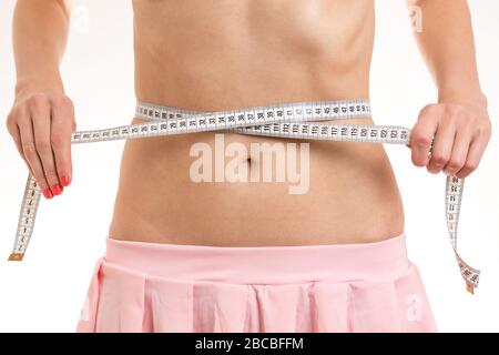 https://l450v.alamy.com/450v/2bcbffm/slim-girl-with-pink-skirt-measures-her-thin-waistline-with-a-tape-measure-royalty-free-stock-photo-2bcbffm.jpg