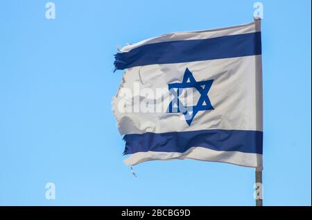 Flag of Israel fluttering in the wind against a blue sky Stock Photo
