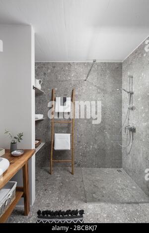 Grey terrazzo walk in shower with wooden details. Stock Photo