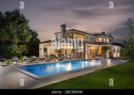 Large luxury stone house with swimming pool surrounded with nature. Stock Photo