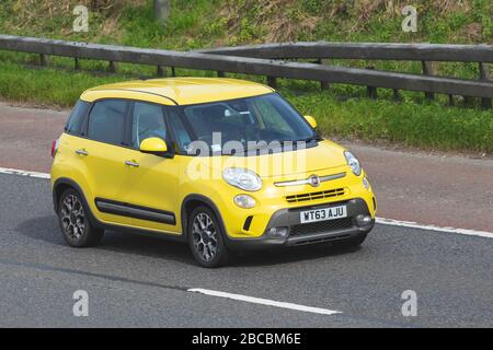 2014 yellow Fiat 500L Trekking Multijet; Vehicular traffic moving vehicles, driving vehicle on UK roads, motors, motoring on the M6 motorway highway Stock Photo