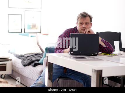 middle-aged man working remotely at home office Stock Photo