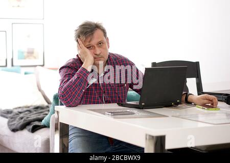 middle-aged man working remotely at home office Stock Photo