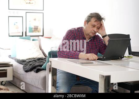middle-aged man working remotely at home office Stock Photo
