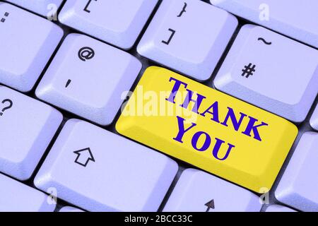 A keyboard with the words THANK YOU in blue lettering on a yellow enter key. Many thanks concept. England, UK, Britain Stock Photo