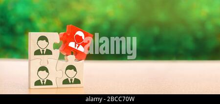 Wooden puzzles with the image of workers. Leadership concept. Stand out from the crowd. The best employee. Human Resource Management and Recruitment. Stock Photo